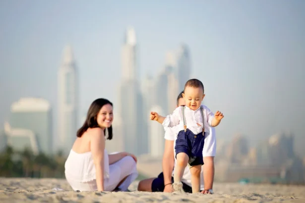 In picture a family couple with walking kid on dubai beach spending vocations and Visit Dubai in Summer: A Comprehensive Guide