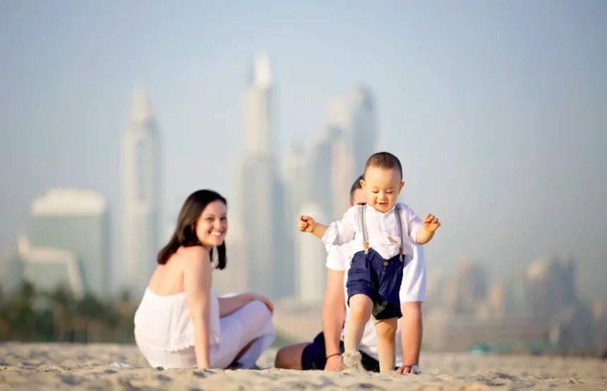 In picture a family couple with walking kid on dubai beach spending vocations and Visit Dubai in Summer: A Comprehensive Guide